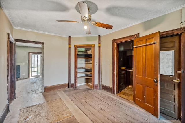 unfurnished bedroom featuring a textured ceiling, crown molding, light wood-style flooring, ceiling fan, and baseboards