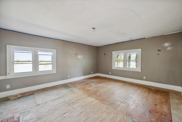 empty room with light wood-style flooring and baseboards