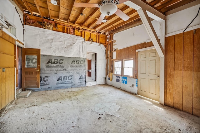 misc room with ceiling fan and wood walls