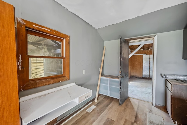 bathroom featuring wood finished floors and vaulted ceiling
