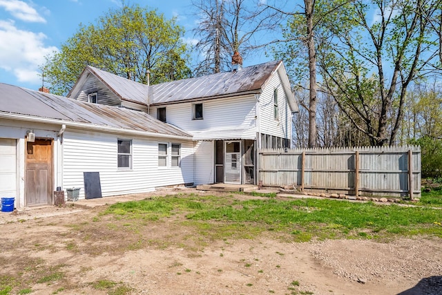 back of house with fence and metal roof