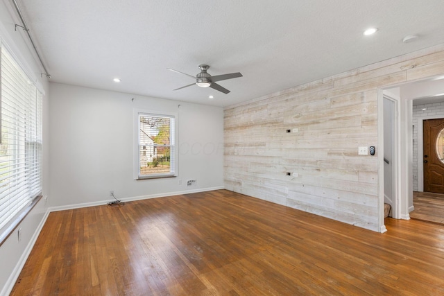 250 E Park St, Westerville, OH 43081 - spare room with ceiling fan, baseboards, wooden walls, recessed lighting, and wood finished floors