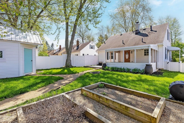250 E Park St, Westerville, OH 43081 - back of house featuring an outdoor structure, a chimney, a yard, a vegetable garden, and a fenced backyard