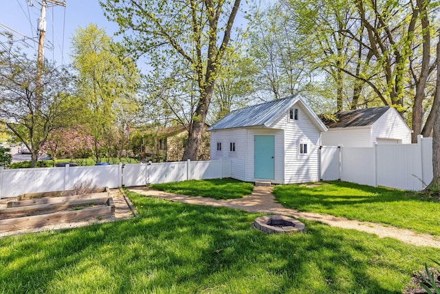 250 E Park St, Westerville, OH 43081 - view of shed with a fenced backyard, a fire pit, and a vegetable garden