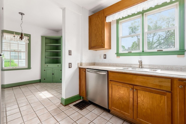kitchen featuring brown cabinetry, dishwasher, a sink, light countertops, and light tile patterned floors