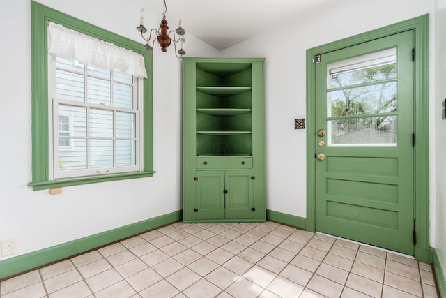 interior space featuring an inviting chandelier, baseboards, and plenty of natural light
