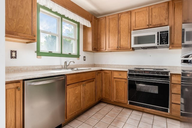 kitchen with stainless steel dishwasher, a sink, black / electric stove, and light countertops