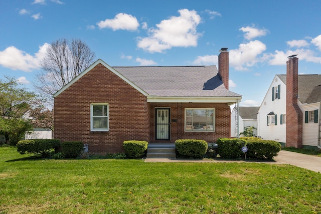 view of front of property with a chimney, brick siding, and a front yard
