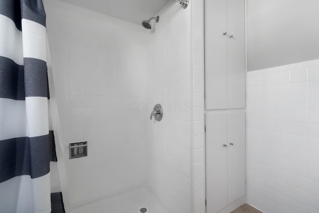 full bathroom with tile walls and a stall shower