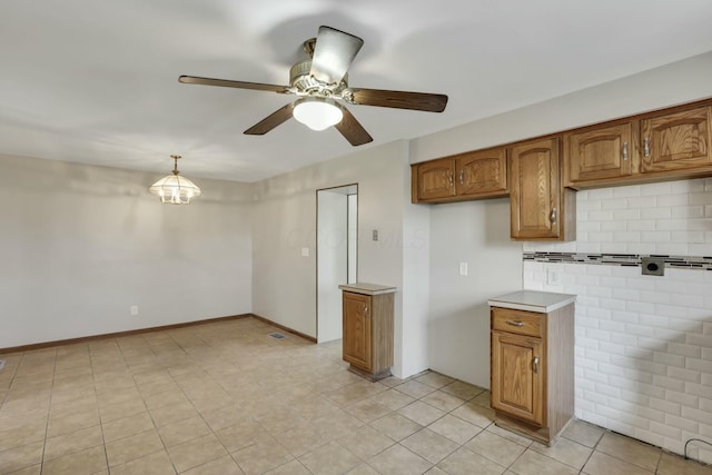 3907 Condit Rd, Sunbury, OH 43074 - kitchen with brown cabinets, a ceiling fan, pendant lighting, and light countertops