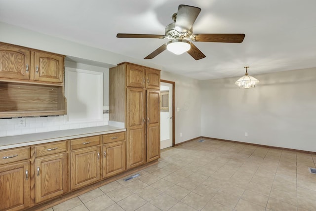 3907 Condit Rd, Sunbury, OH 43074 - kitchen featuring brown cabinets, light countertops, tasteful backsplash, and ceiling fan with notable chandelier
