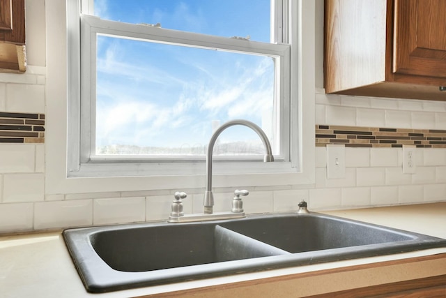 3907 Condit Rd, Sunbury, OH 43074 - details featuring backsplash, brown cabinetry, and a sink