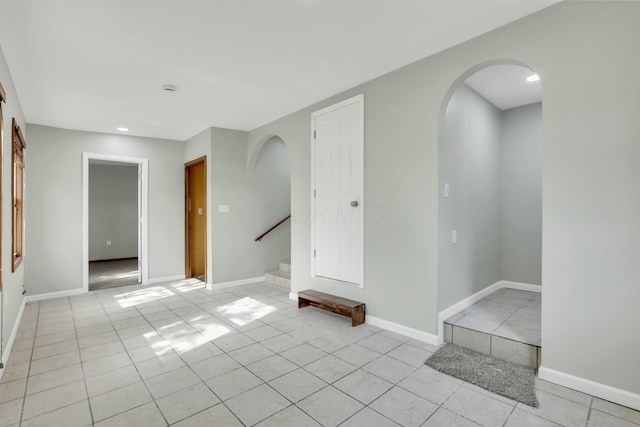 3907 Condit Rd, Sunbury, OH 43074 - empty room with stairway, baseboards, arched walkways, and light tile patterned floors