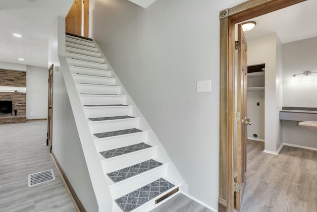 3907 Condit Rd, Sunbury, OH 43074 - stairs with baseboards, wood finished floors, visible vents, and a brick fireplace