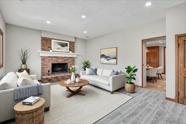3907 Condit Rd, Sunbury, OH 43074 - living area featuring baseboards, a brick fireplace, wood finished floors, and recessed lighting