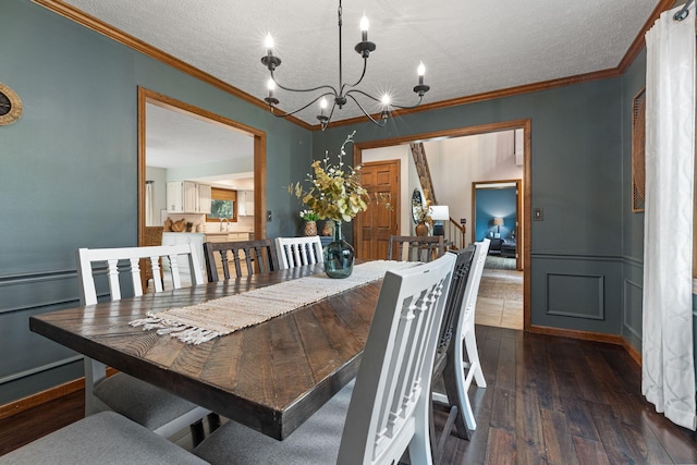 dining area featuring a chandelier, ornamental molding, hardwood / wood-style floors, and a textured ceiling