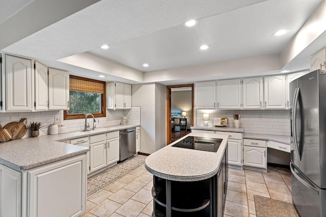 kitchen featuring appliances with stainless steel finishes, a sink, decorative backsplash, light countertops, and recessed lighting