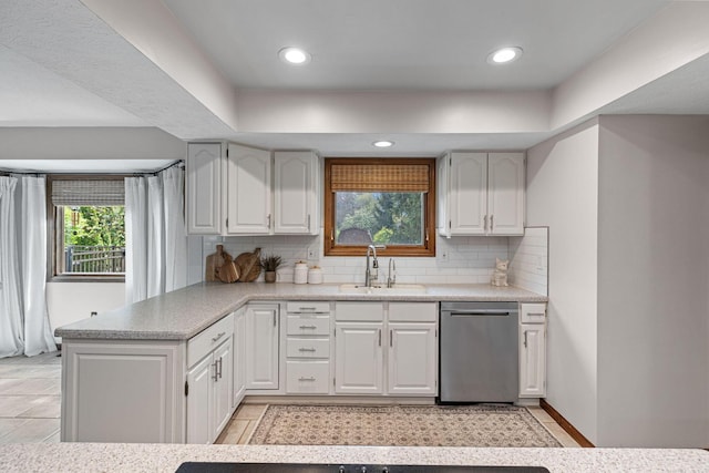 kitchen with dishwasher, a sink, backsplash, light countertops, and recessed lighting