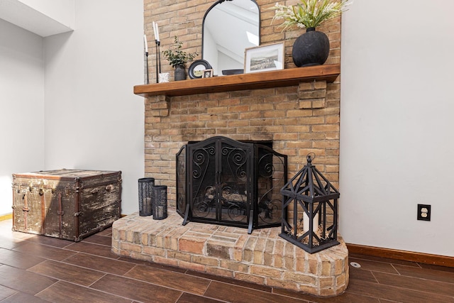 detailed view of wood finished floors, baseboards, and a fireplace