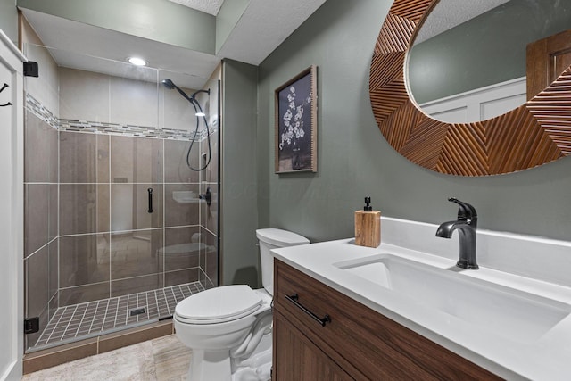bathroom featuring toilet, a stall shower, and vanity