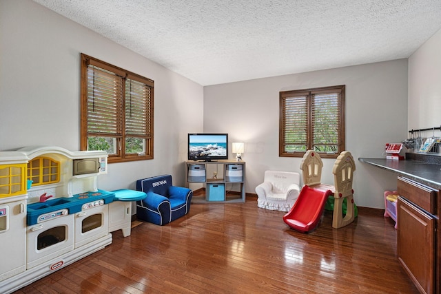 game room featuring wood-type flooring and a textured ceiling