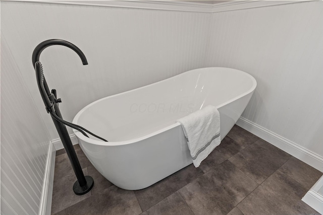 bathroom view of baseboards and a freestanding bath