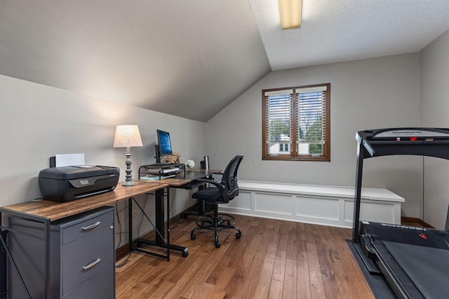 home office featuring dark wood-type flooring and vaulted ceiling