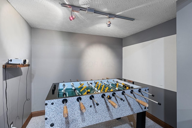 rec room featuring baseboards, carpet, and a textured ceiling