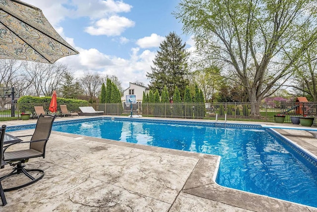 view of swimming pool with a diving board, a patio area, and fence