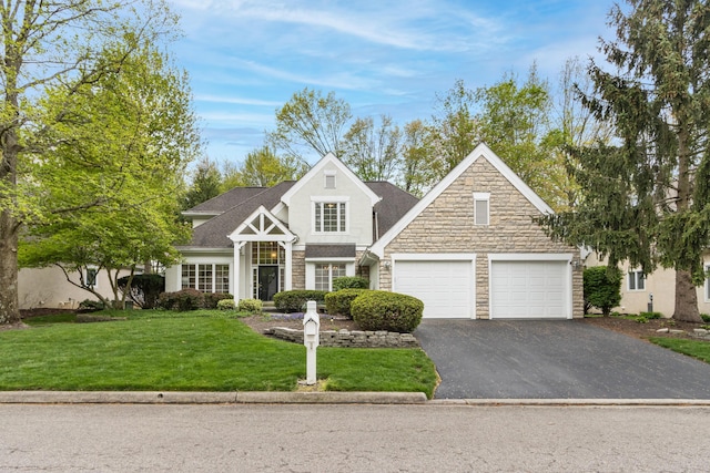 view of front facade featuring aphalt driveway, a garage, stone siding, stucco siding, and a front yard