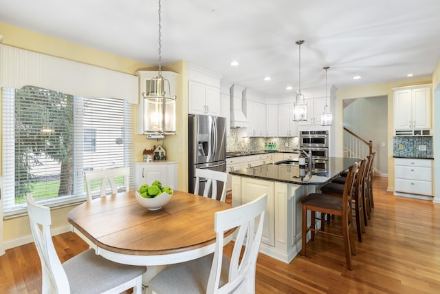 dining room featuring stairs, recessed lighting, baseboards, and light wood-type flooring