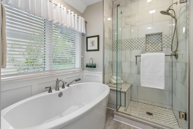 full bath featuring a decorative wall, a stall shower, and a soaking tub