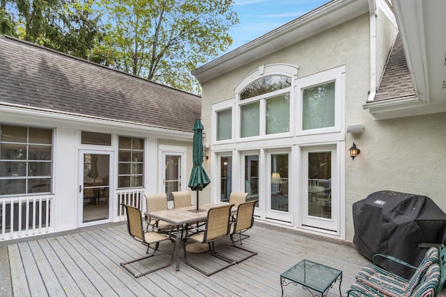 deck featuring outdoor dining space and grilling area