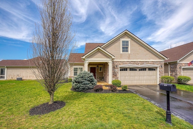 craftsman-style house featuring stone siding, a front lawn, and aphalt driveway