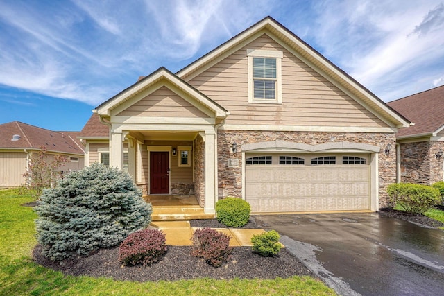 craftsman house featuring driveway and stone siding