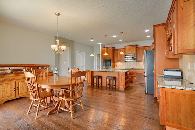 dining room featuring recessed lighting, dark wood-style flooring, a textured ceiling, and a chandelier