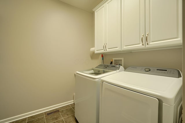laundry room with dark tile patterned floors, independent washer and dryer, visible vents, cabinet space, and baseboards