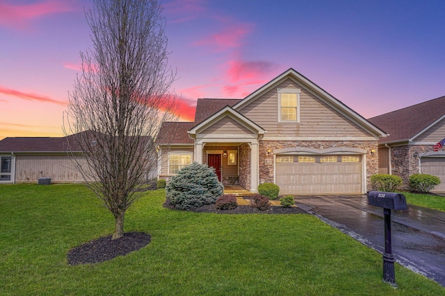 view of front facade with a front lawn, aphalt driveway, and stone siding