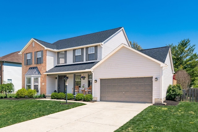 traditional-style home with a front lawn, concrete driveway, covered porch, fence, and an attached garage