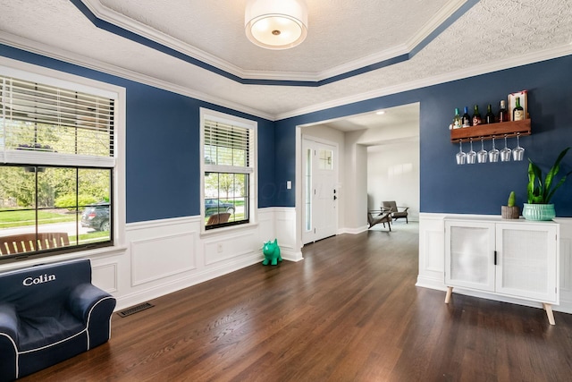 foyer featuring visible vents, a textured ceiling, dark wood-style floors, and wainscoting