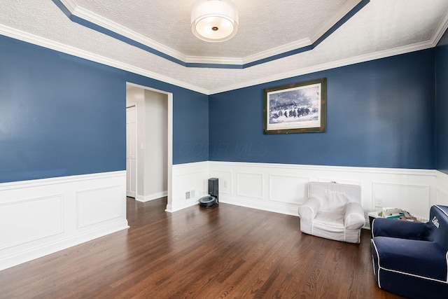 sitting room with wainscoting, wood finished floors, and a textured ceiling