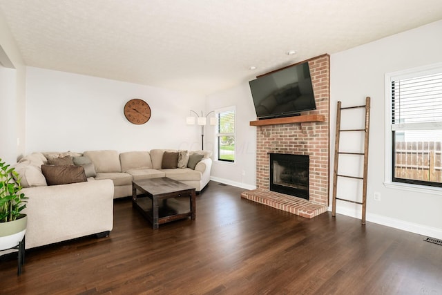 living room with dark wood-type flooring, a fireplace, and baseboards