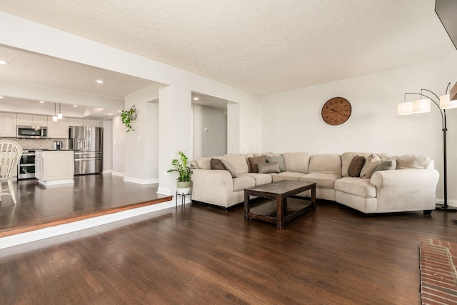 living room featuring a textured ceiling, baseboards, recessed lighting, and dark wood-type flooring
