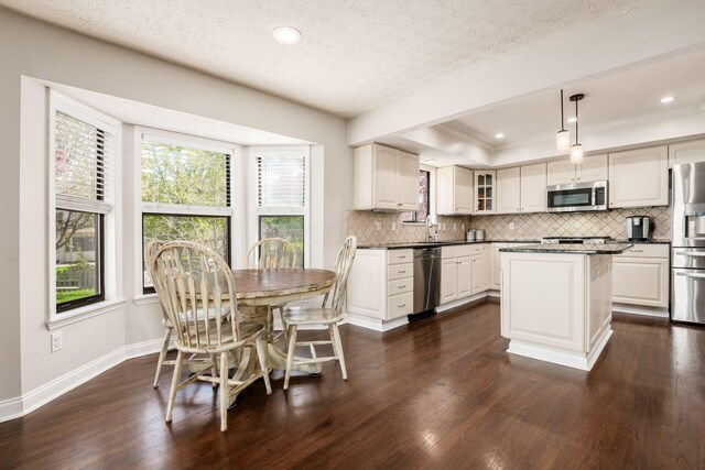 kitchen with dark countertops, tasteful backsplash, dark wood finished floors, baseboards, and appliances with stainless steel finishes
