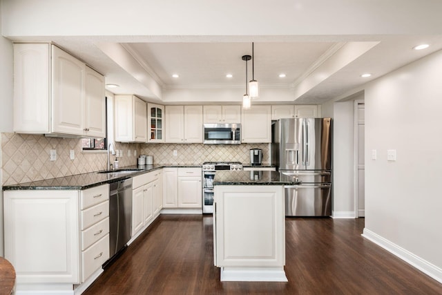 kitchen with stainless steel appliances, a tray ceiling, a sink, dark wood-type flooring, and a center island