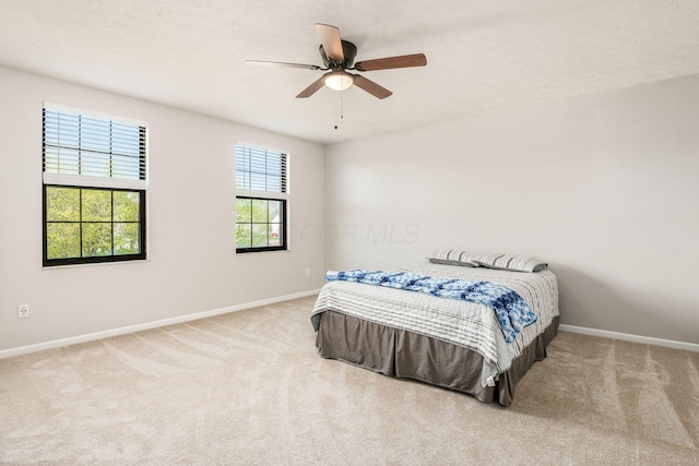 carpeted bedroom with baseboards and ceiling fan