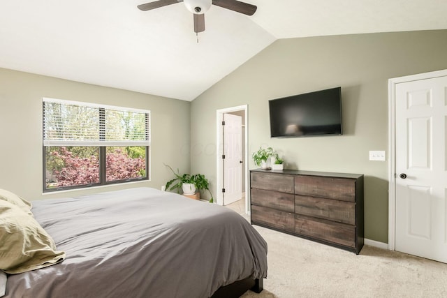 bedroom with vaulted ceiling, light colored carpet, and ceiling fan
