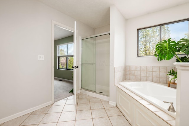full bath with baseboards, tile patterned flooring, a garden tub, and a stall shower