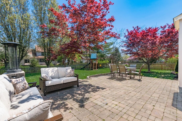 view of patio / terrace with a fenced backyard, an outdoor living space, a playground, and outdoor dining area