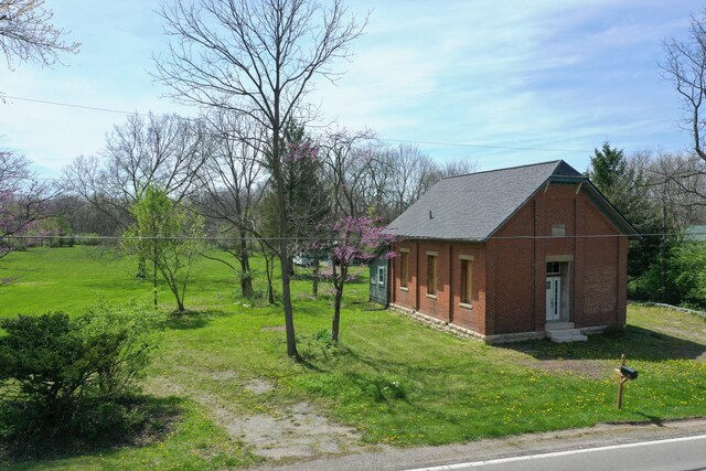 2263 Amity Rd, Hilliard, OH 43026 - view of side of home with brick siding, roof with shingles, a yard, and entry steps
